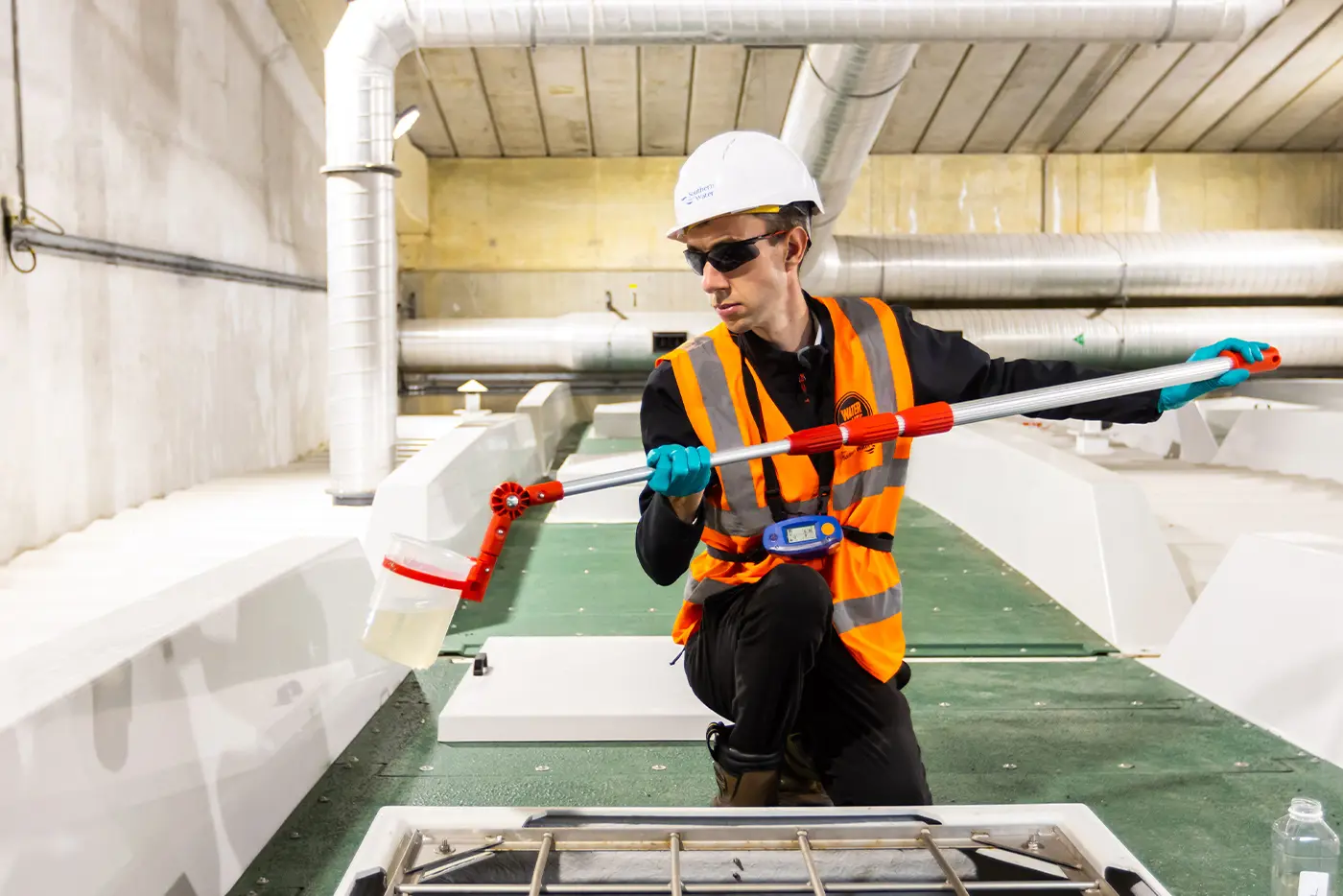 A Southern Water engineer taking a sample of water at a water treatment works