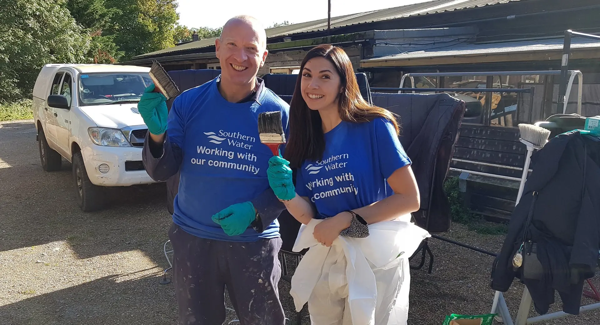 Southern water volunteers working with their community holding paintbrushes