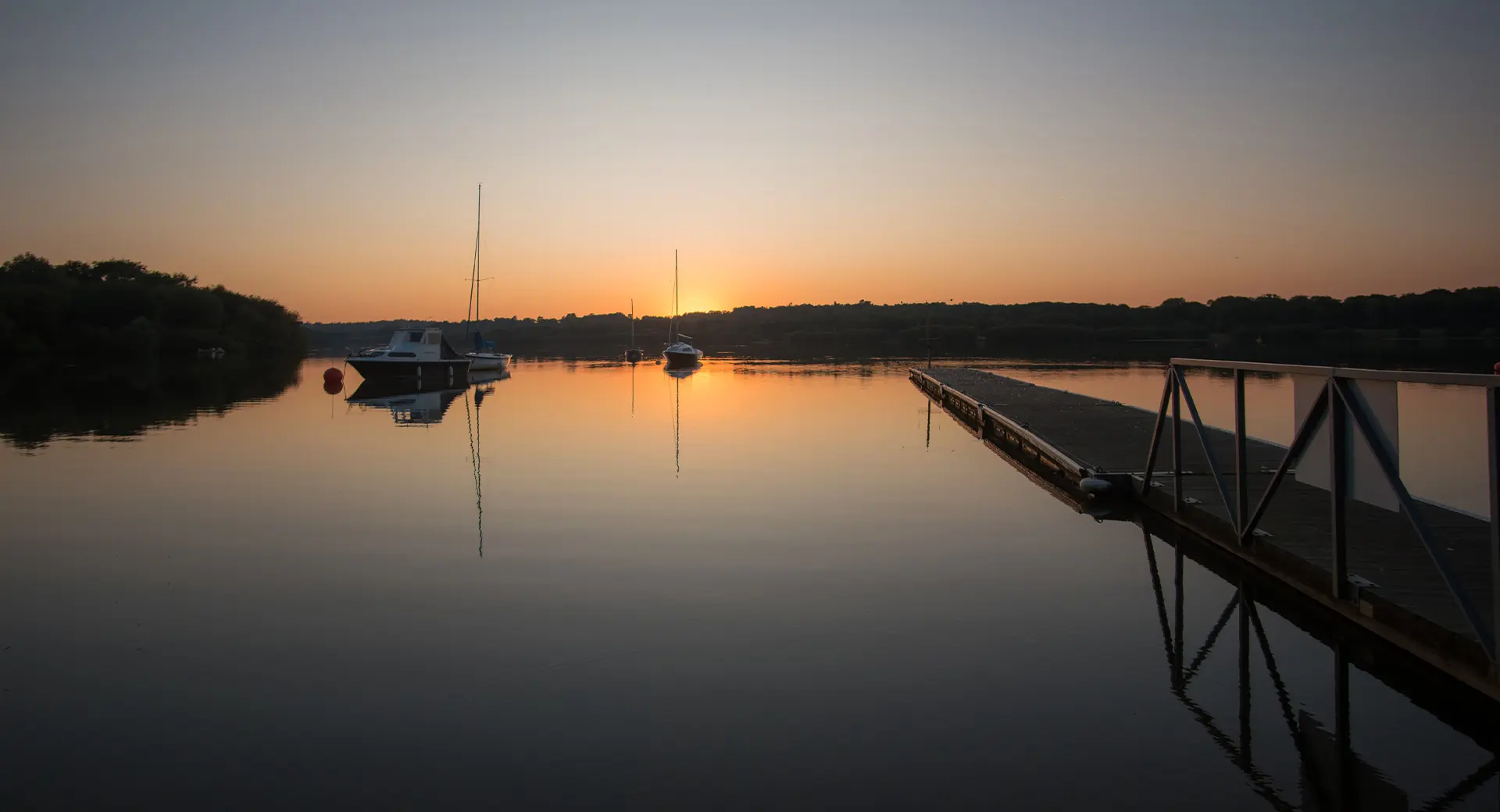 Boats on Weir Wood Reservoir at sunset