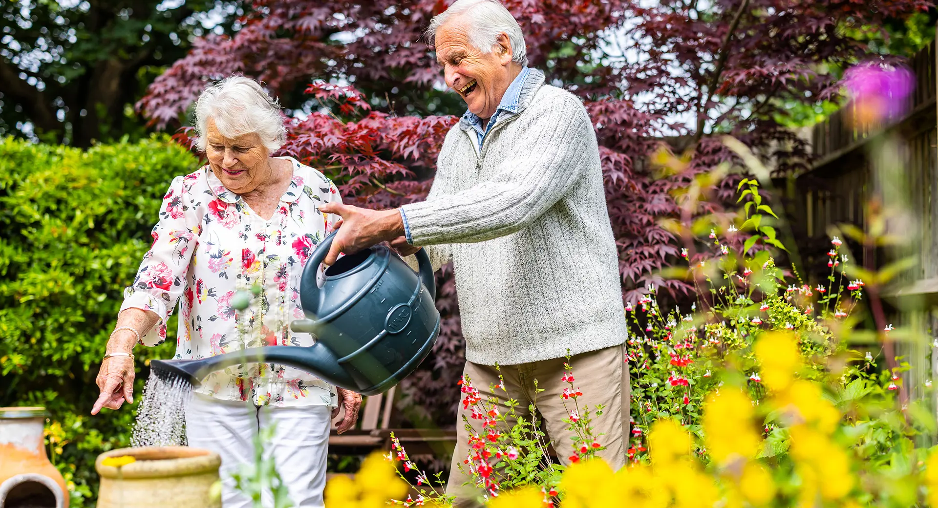 Elderly customers watering their garden with a watering can